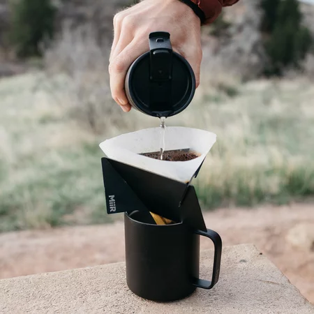 Filtre en métal noir pour café MiiR Pourigami Dripper, idéal pour préparer du café filtré.