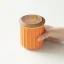 Récipient en porcelaine avec un couvercle en bois dans la main. Récipient en porcelaine avec un couvercle en bois dans la main.
