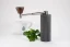 Timemore Nano Grinder mit Tasse Kaffee und Pflanze