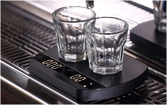 Digitale Kaffeewaage auf einer Felicita ARC Kaffeemaschine mit Gläsern.