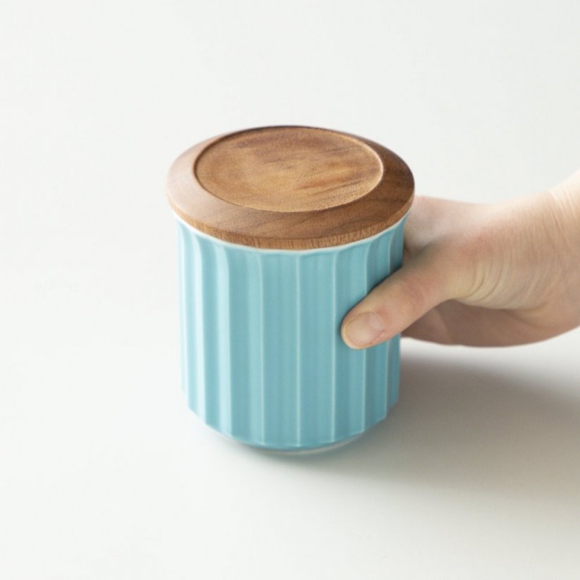 Keramik-Kaffeedose Origami in der Hand.