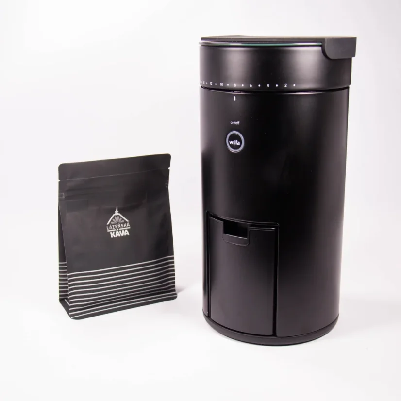 Čierny elektrický mlynček na kávu na bielom pozadí s balíčkom kávy
