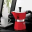 Cafetera Bialetti Moka Express al lado de una taza blanca para café.