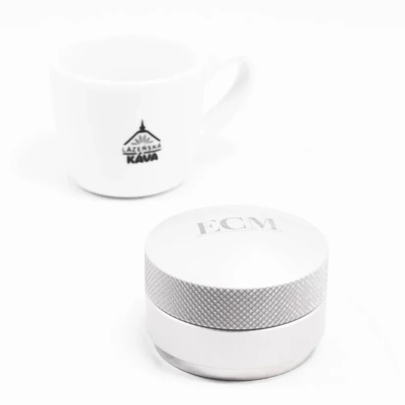 ECM coffee tamper with coffee in the background.