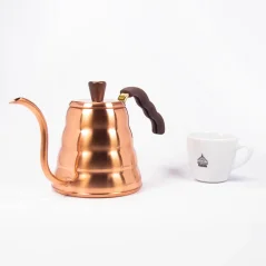 Hario Buono copper kettle with a capacity of 0.9L next to a cup of coffee.