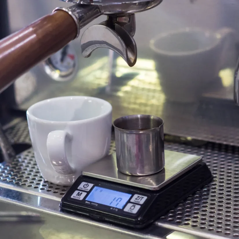 Balance numérique Rhinowares sur une machine à café à levier avec une tasse blanche.