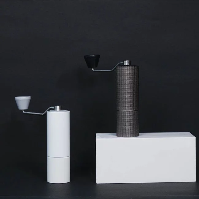 Biely a čierny mlynček Timemore Chestnut C2 Max na ručné mletie kávy.