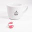 Tazza rosa del badge Edo accanto alla tazza del caffè.