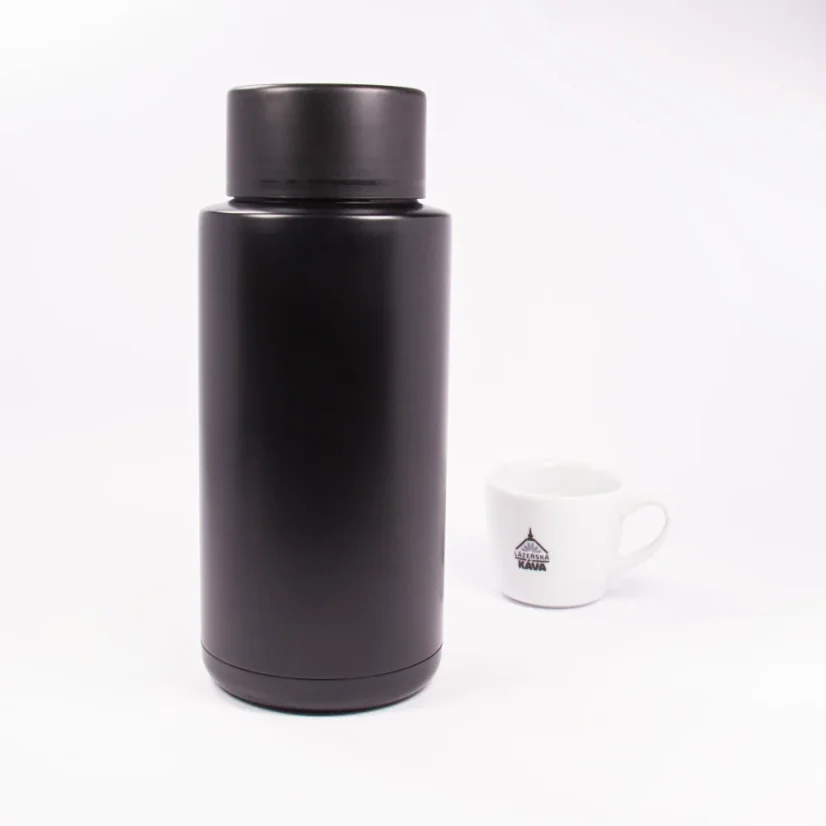 Ceramic thermos from the back with coffee in the background