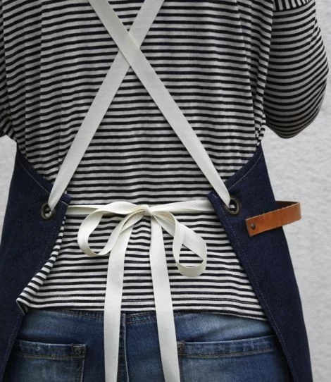 Denim blue barista apron with a model, detailed view of the back tie