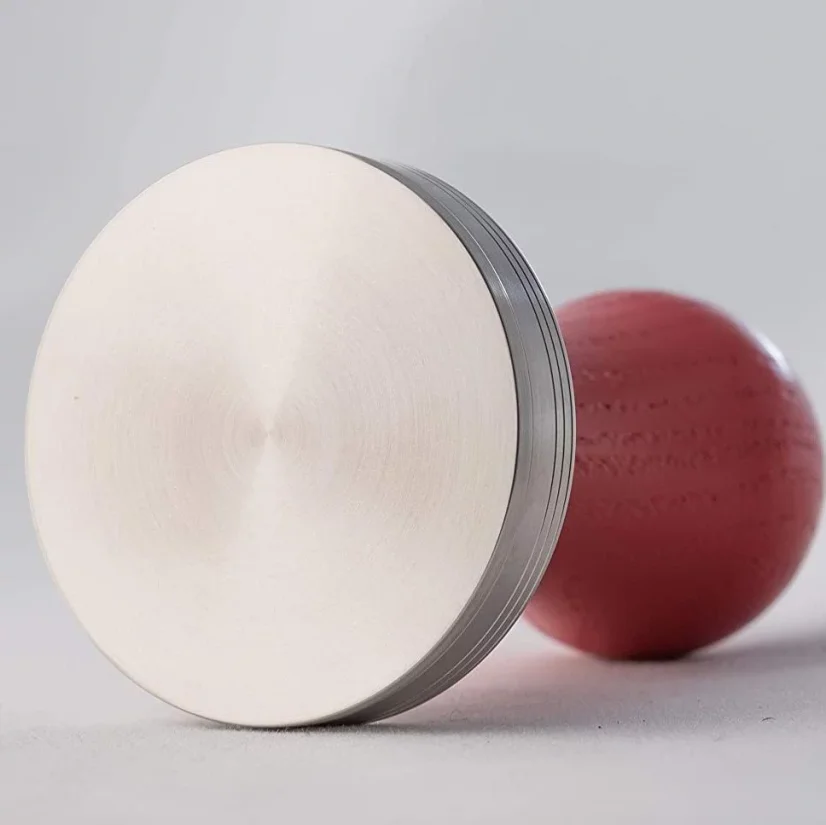 Lelit tamper base with red handle.