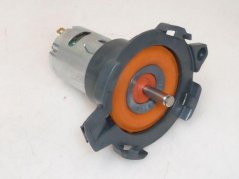 Mëschmotor mat Basis, schwaarze Kierper, gro Montagebasis an orangem Dichtungsrank ronderëm d'Welle Mëschmotor mat Basis, schwaarze Kierper, gro Montagebasis an orangem Dichtungsrank ronderëm d'Welle