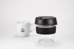 Glass thermal mug with a black lid and black rubber holder, 227 ml capacity, with a cup of coffee
