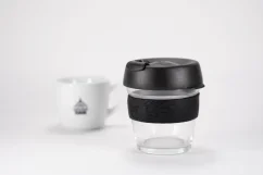 Gobelet thermique en verre avec couvercle noir et poignée en caoutchouc noir, d'une capacité de 227 ml avec une tasse de café.