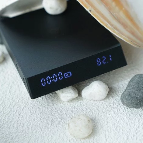Balance numérique pour espresso Timemore Black Mirror Nano en détail avec une décoration de petits cailloux