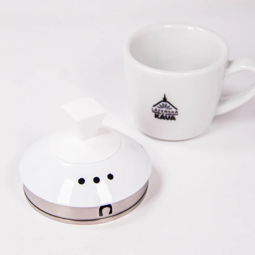 Gros plan sur le couvercle d'une bouilloire électrique Brewista à côté de notre tasse avec logo.