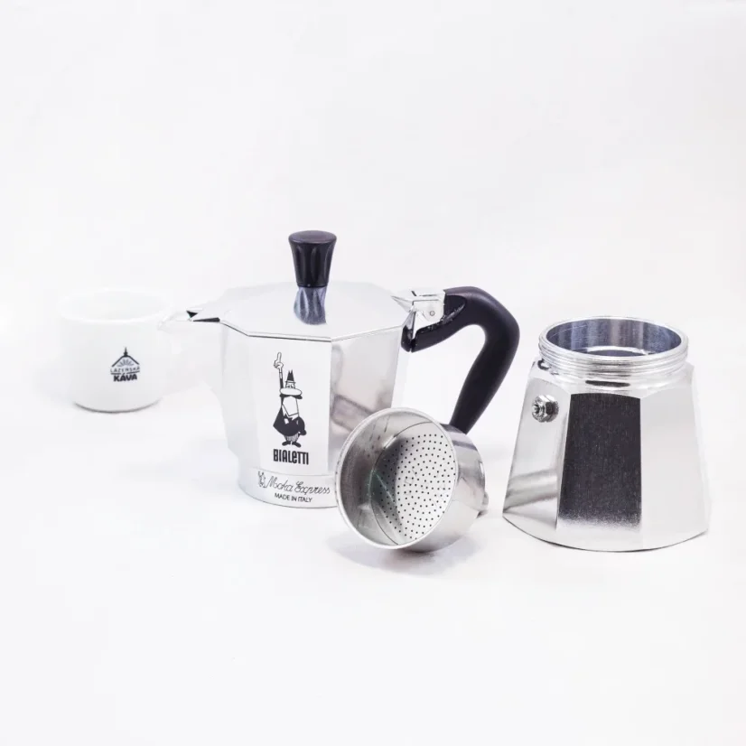 Pièces individuelles de la cafetière Moka Bialetti Moka Express accompagnées d'une tasse avec un logo.