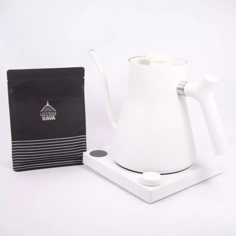 White electric kettle on a white background with a package of spa coffee