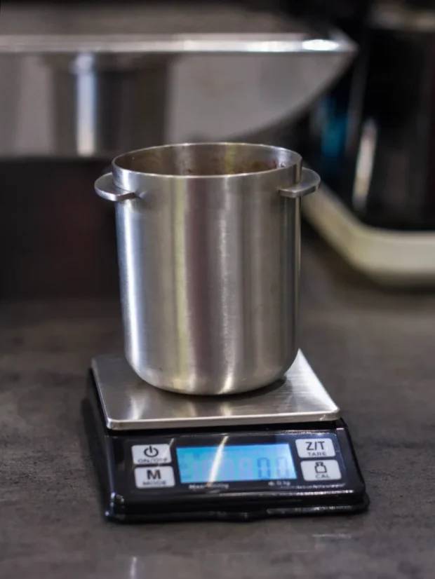 Balance numérique Rhinowares avec un doseur de café moulu sur une table grise