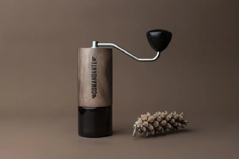 Manual Comandante grinder in Virginia Walnut color on a brown background.