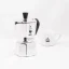 Silver Bialetti Moka Express pot for 2 cups on a white background with a cup of coffee, front view Silver Bialetti Moka Express pot for 2 cups on a white background with a cup of coffee, front view
