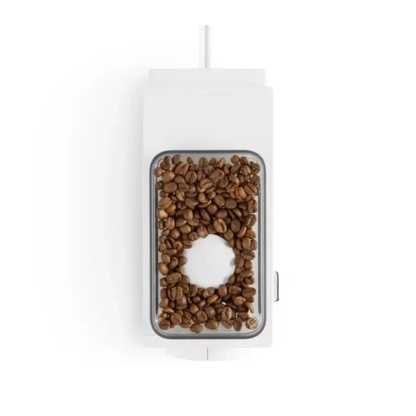 Detail of the Fellow Ode Brew grinder hopper with coffee on a white background