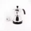 Pohľad zo strany na striebornú moka kanvicu značky Bialetti Moka Timer a v pozadí položený šálka s logom.