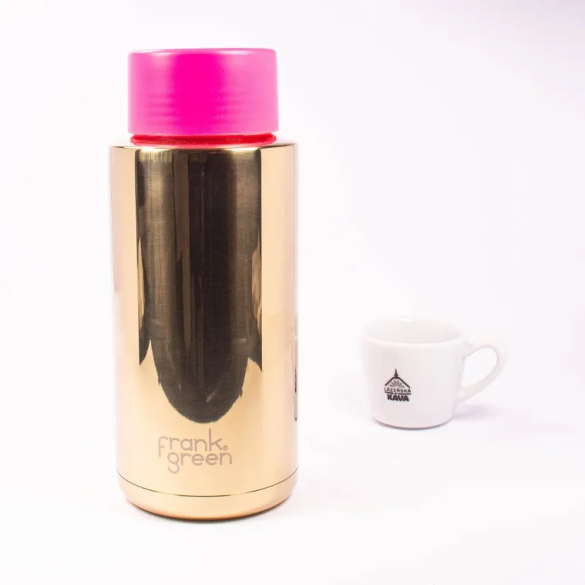 Ceramic thermos from the front with coffee in the background