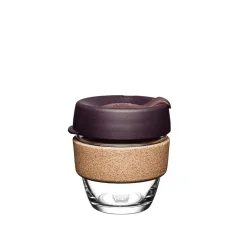 Sklenený KeepCup s červeným viečkom na kávu so sebou.